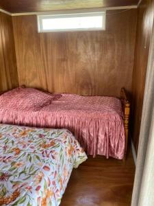 ein kleines Schlafzimmer mit einem Bett mit Fenster in der Unterkunft Waitomo Farmstay - Morepork Cabin 7 in Waitomo Caves