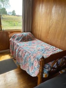 ein Schlafzimmer mit einem Bett und einem Fenster in der Unterkunft Waitomo Farmstay - Morepork Cabin 7 in Waitomo Caves