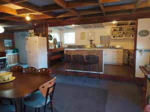 eine Küche mit Tisch und Stühlen und einem Kühlschrank in der Unterkunft Waitomo Farmstay - Morepork Cabin 7 in Waitomo Caves