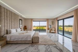 Un dormitorio con una cama grande y una ventana grande en Appartement de rêve à Taghazout Vue mer exceptionnelle, en Agadir nʼ Aït Sa 278 fotos más