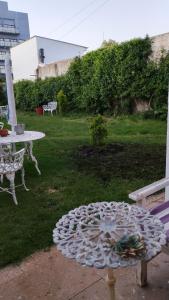 ein Tisch und eine Bank in einem Garten mit einem Tisch und Stühlen in der Unterkunft Quincho in Mar del Plata