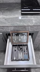 a tray with utensils in a drawer in a table at Aurum Azure in Nizwa