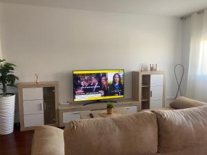 a living room with a couch and a flat screen tv at Apartamento Cuchia in Cuchia