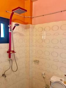 ein Bad mit einer Dusche mit rotem Duschkopf in der Unterkunft Studio in Dakar