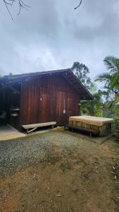 un edificio in legno con due panchine di fronte di Rancho do Brow a Camboriú