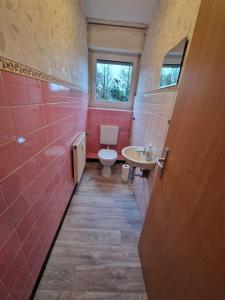 a bathroom with a toilet and a sink and a window at RHE 6P Unterkunft in Rheine
