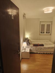 a small bedroom with a bed and a table at Ginjals-67 Quarto Branco in Almargem do Bispo