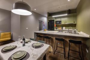 a kitchen with two tables and a bar with chairs at THE SPOT- holiday concept in Santa Cruz