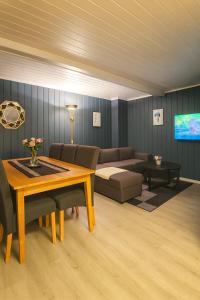 a living room with a couch and a table at Sentralt og elegant opphold nær alt in Lillehammer
