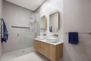 un baño con dos lavabos y una ducha en Peninsula Sea Breeze, en Safety Beach 19 fotos más