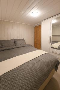 a bedroom with a large bed and a closet at Sentralt og elegant opphold nær alt in Lillehammer