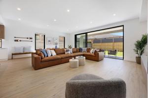 una sala de estar con 2 sofás marrones y una ventana grande en Peninsula Sea Breeze, en Safety Beach