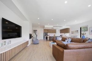 Una gran sala de estar con un sofá y un televisor. en Peninsula Sea Breeze, en Safety Beach