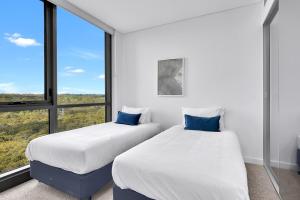 悉尼Stunning Wyndel Macquarie Apartment的一间有大窗户的房间里有两张床 更多4张照片