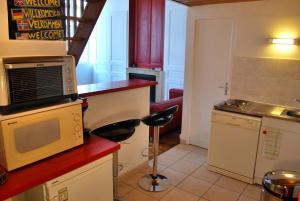 a kitchen with a microwave and a counter with stools at L'Appartement du Parc in Lyon