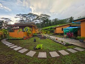 una casa con un jardín delante de ella en Revatua Lodge - Piscine privée et Petit-déjeuner inclus, 