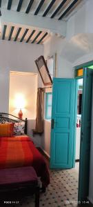 a bedroom with a bed and a blue door at Dar darko in Essaouira