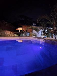 una gran piscina por la noche con luces azules en Revatua Lodge - Piscine privée et Petit-déjeuner inclus, 