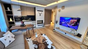 a living room with a large flat screen tv on a wall at Snowfall Luxury Suites Jahorina in Jahorina