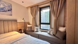 a bedroom with a bed and a large window at Snowfall Luxury Suites Jahorina in Jahorina +10 photos