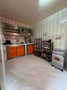 - une cuisine avec des armoires orange et une cuisinière dans l'établissement Chez toi express, à Derklé