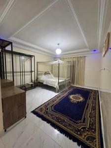 une grande chambre avec un lit et un tapis bleu dans l'établissement Chez toi express, à Derklé