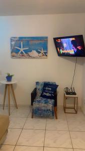 a living room with a couch and a tv on the wall at Ground floor apartment accommodation in Itanhaem in Itanhaém