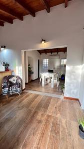 een woonkamer met een witte tafel en houten vloeren bij Playa Hostel in Santa Rosa de Calamuchita