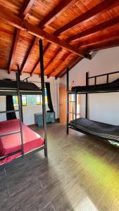 2 stapelbedden in een kamer met een houten plafond bij Playa Hostel in Santa Rosa de Calamuchita