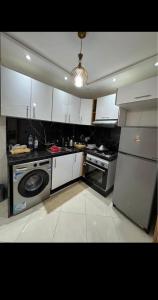 a kitchen with white cabinets and a stove and a dishwasher at Residence Ritaj in Agadir