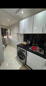 a kitchen with a sink and a washing machine at Residence Ritaj in Agadir