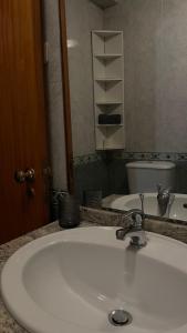 a bathroom with a white sink and a toilet at The Calm Residence - Gondomar 