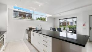 a kitchen with a black counter top and some windows at Diamond Luxury Central Queenstown in Queenstown