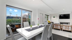 a dining room with a white table and chairs at Diamond Luxury Central Queenstown in Queenstown