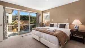 a bedroom with a large bed and a large window at Stewart Lodge Luxury Spa in Queenstown +22 photos