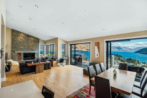 a living room with a fireplace and a large window at Lake Panorama Villa in Queenstown