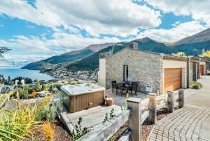 a stone house with a jacuzzi in the backyard at Lake Panorama Villa in Queenstown +19 photos