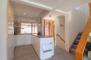 a kitchen with white cabinets and a counter top at The Lodges in Queenstown +10 photos