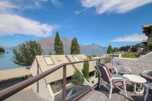 a balcony with chairs and a view of the water at The Lodges in Queenstown