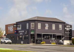 Un edificio negro con un coche aparcado delante. en Recreation Hotel, en Greymouth