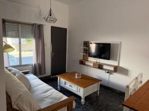 a living room with a couch and a table and a tv at Casa céntrica in Carmelo