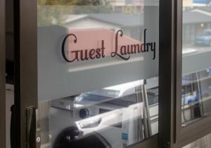 a glass window with a sign that reads guest laundry at Recreation Hotel in Greymouth