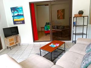 a living room with a couch and a table at Vacation house in Tahiti in Punaauia