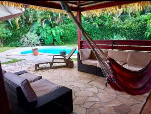 a hammock on a patio next to a pool at Vacation house in Tahiti in Punaauia