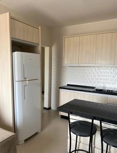 una cucina con frigorifero, tavolo e sedie di Casa com vista para o mar e perto do centro a Imbituba Altre 10 foto