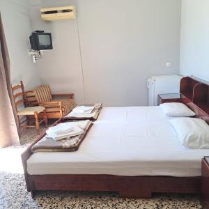 a bedroom with a bed and a tv and a chair at Oasis room in Néa Michanióna