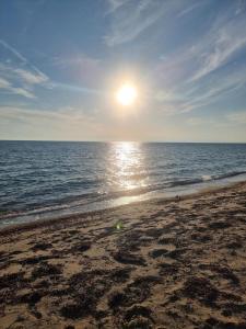 a beach with the sun rising over the ocean at Oasis room in Néa Michanióna