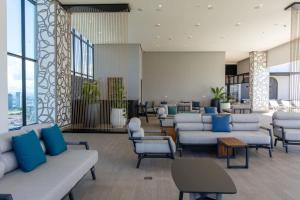 a waiting room with couches and chairs and windows at Arcadia - Fully Furnished 2 Bedroom Apartment - 2705 in Panama City