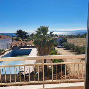 a view from the balcony of a house with a palm tree at Oasis room in Néa Michanióna