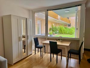 une salle à manger avec une table et des chaises et une fenêtre dans l'établissement Stylish Modern Apartment with Patio near Vienna, à Wiener Neudorf